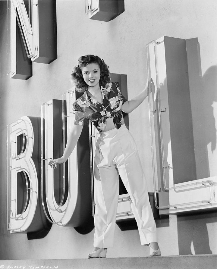 Shirley Temple plays the misbehaving teenage girl while cavorting on a Bullock's sign in Director Richard Wallace’s comedy “Kiss and Tell”, 1945.